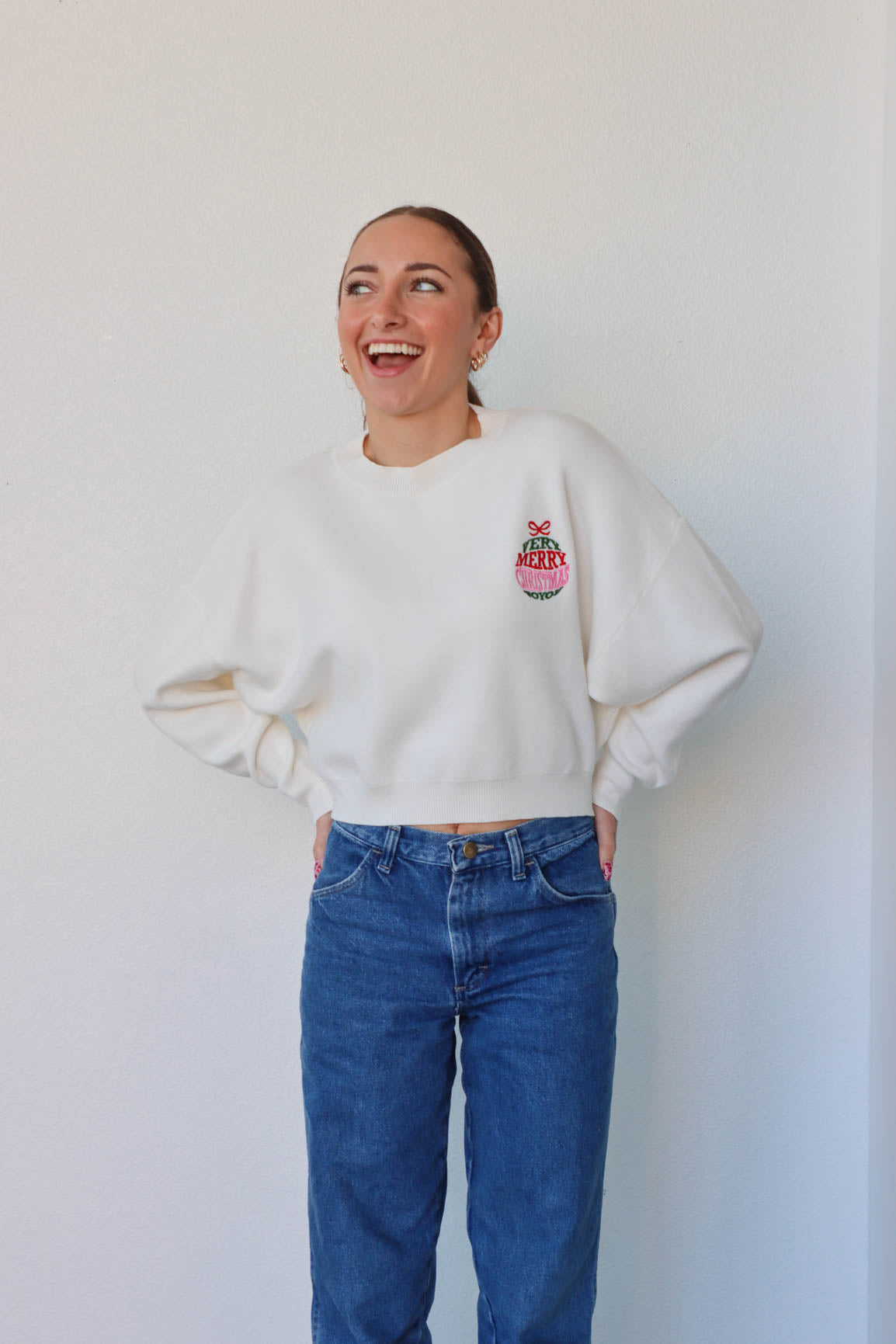 girl wearing white "very merry christmas" sweater