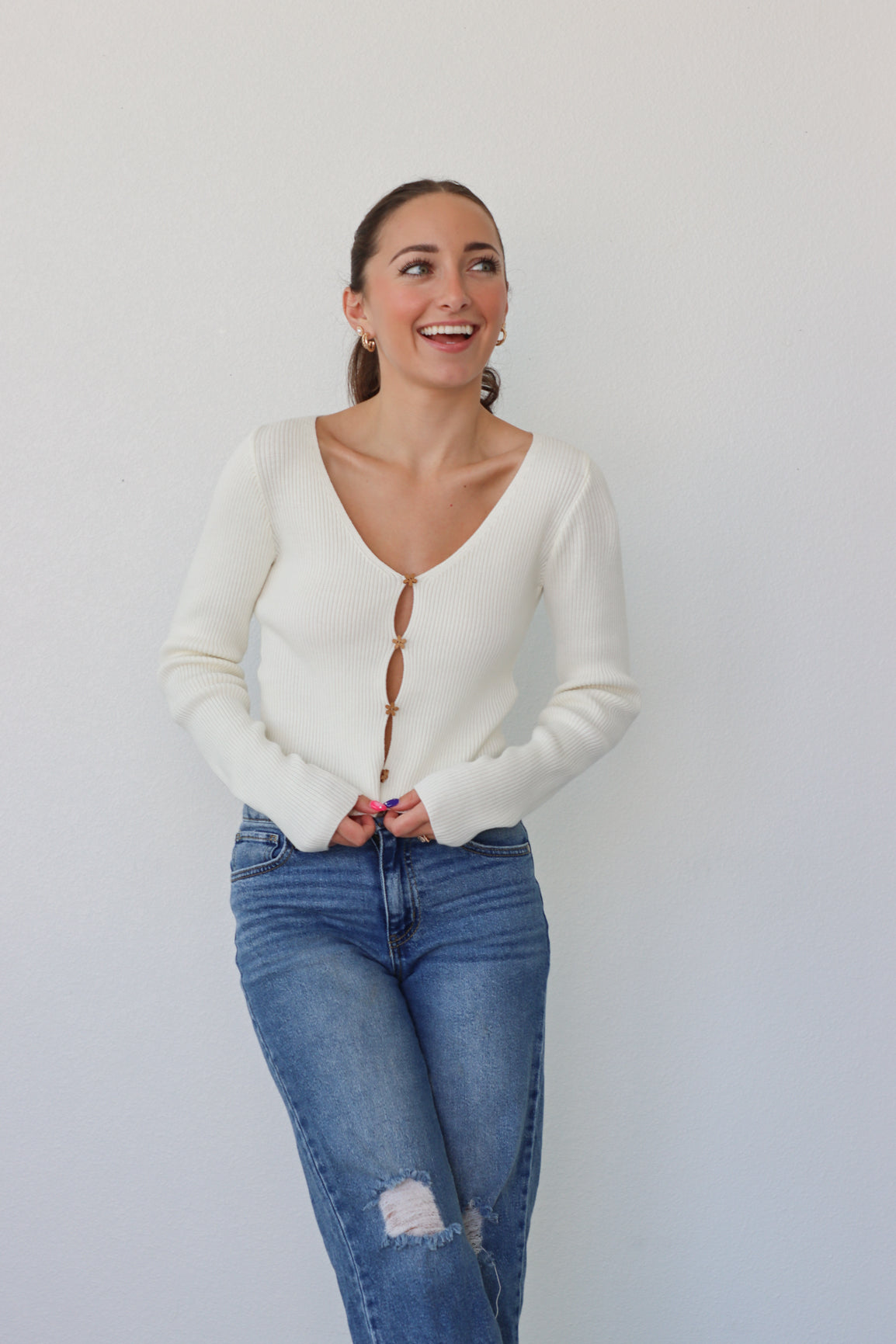 girl wearing cream cardigan with flower buttons