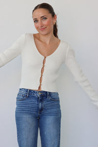 girl wearing cream cardigan with flower buttons