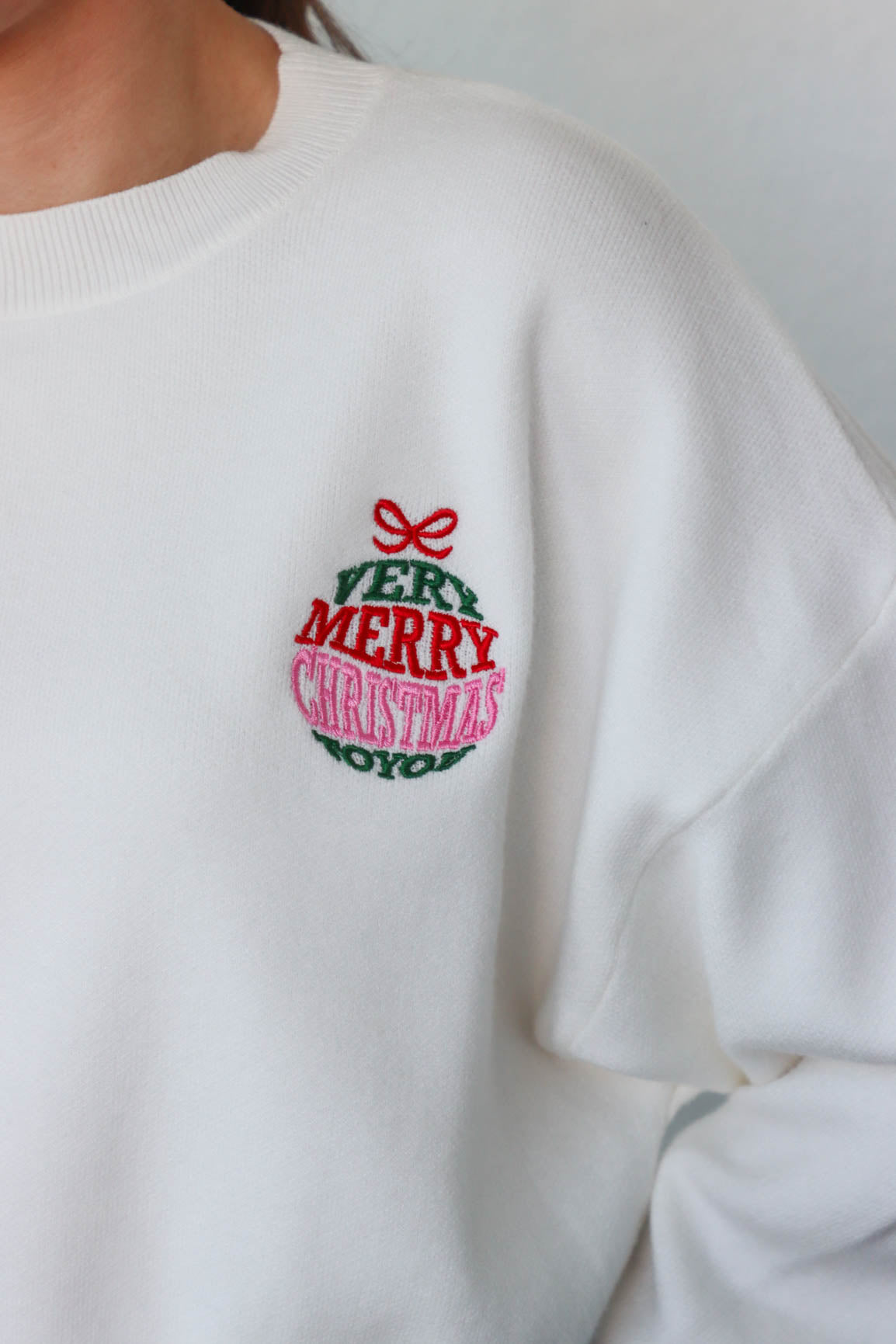 girl wearing white "very merry christmas" sweater