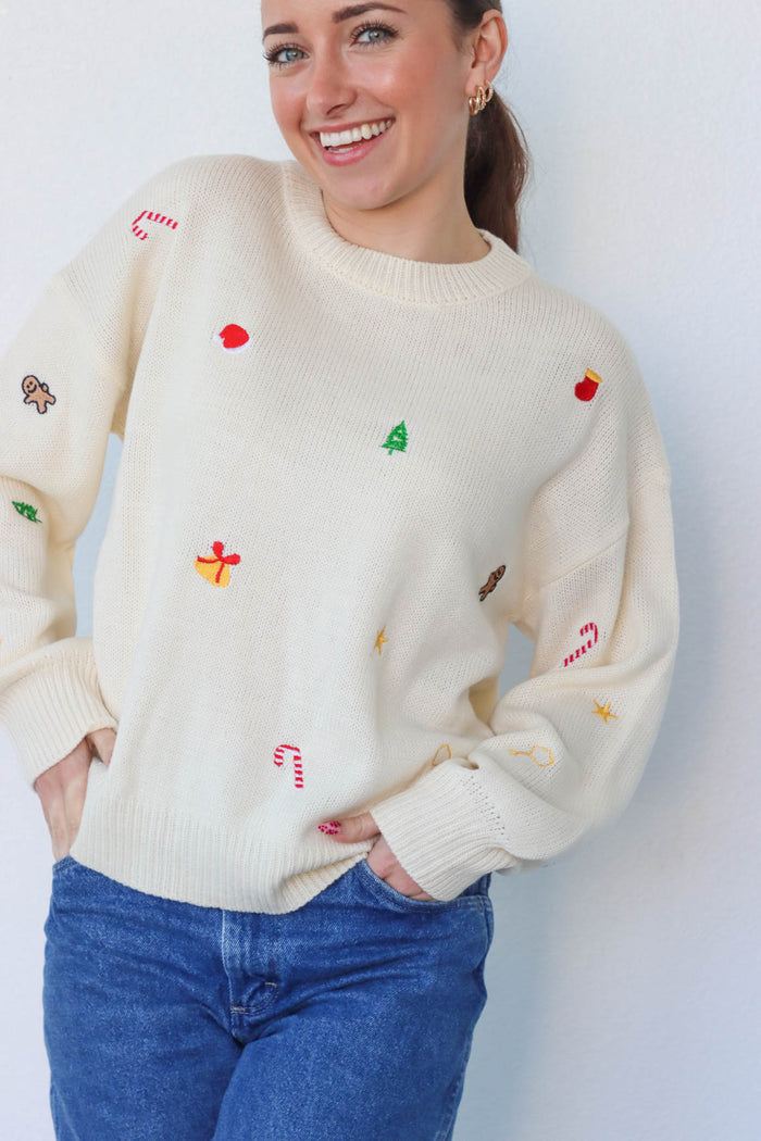 girl wearing cream embroidered holiday sweater