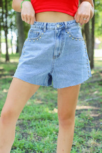 girl wearing denim shorts with silver studd accents