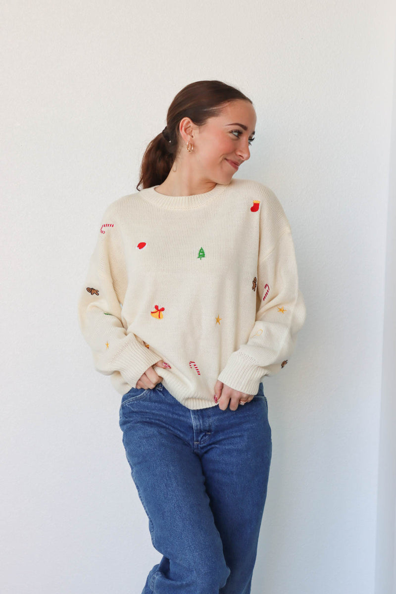 girl wearing cream embroidered holiday sweater