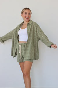 girl wearing sage green checkered set; button down shirt and shorts