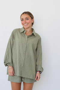 girl wearing sage green checkered set; button down shirt and shorts