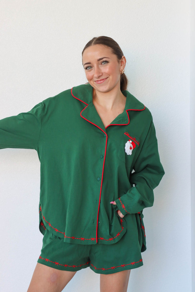 girl wearing dark green santa pajamas