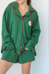 girl wearing dark green santa pajamas