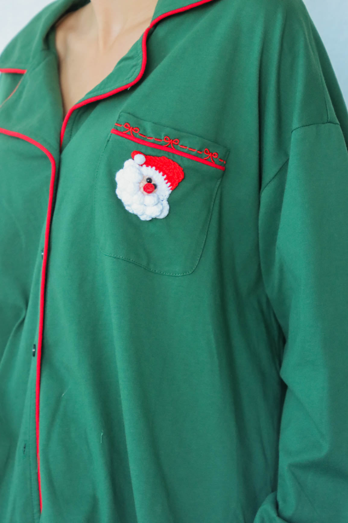 girl wearing dark green santa pajamas