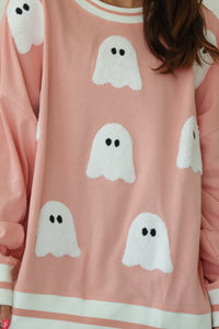 girl wearing pink crewneck with ghost patches