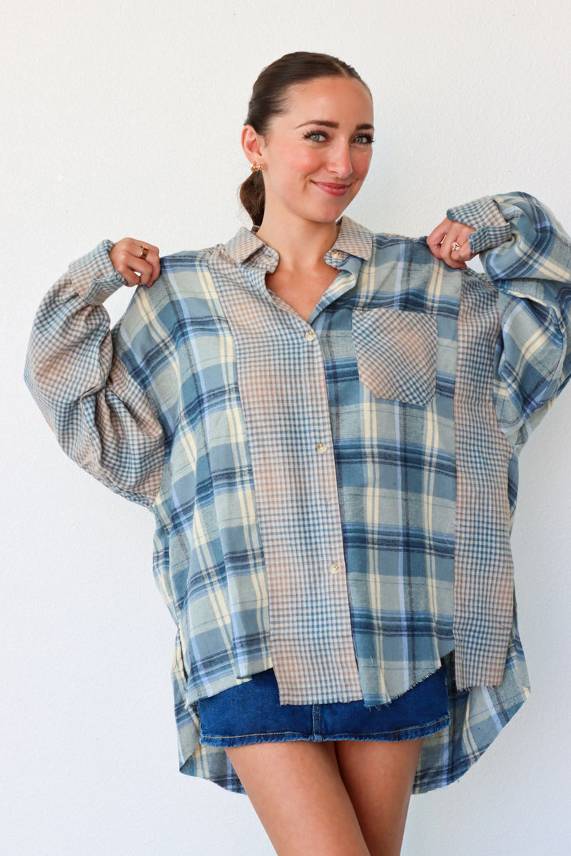 Woman wearing a blue and beige plaid shirt over a white background