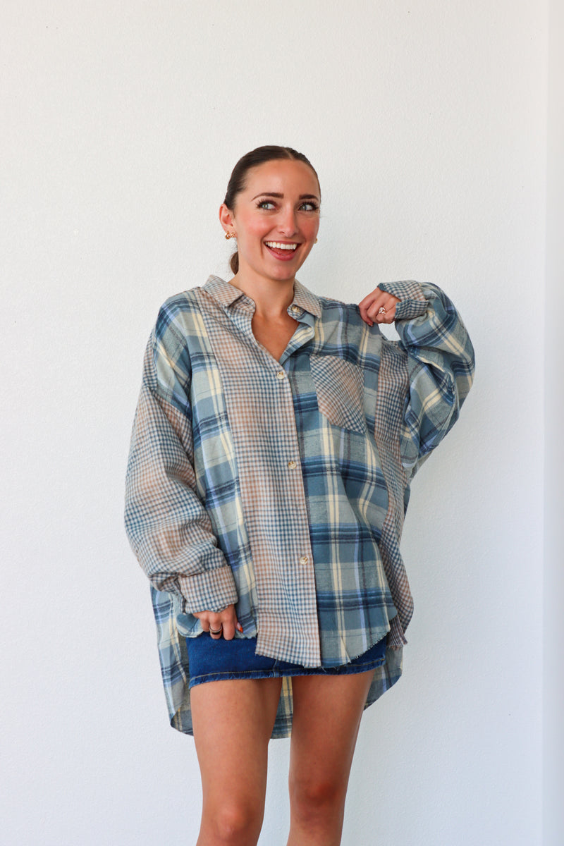 Woman wearing a plaid shirt and denim shorts against a white background