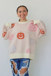 girl wearing cream sweater with pastel pumpkins