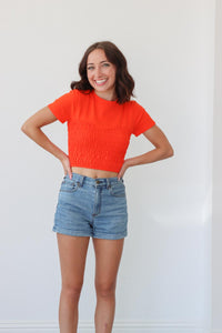 girl wearing orange ruched short sleeve shirt