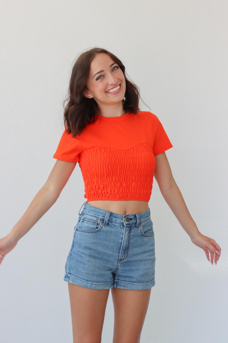 girl wearing orange ruched short sleeve shirt