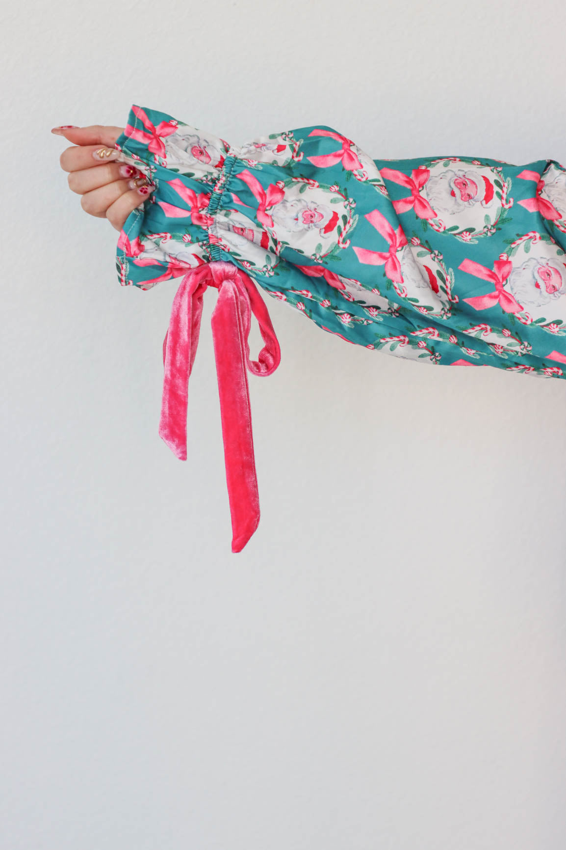 girl wearing teal and pink silk santa pajamas