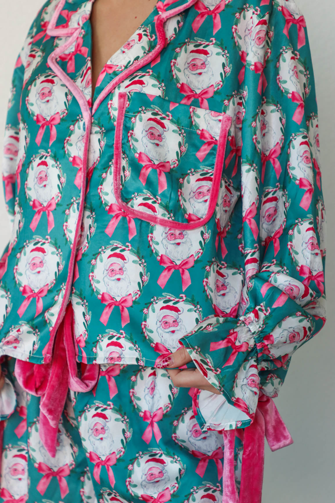 girl wearing teal and pink silk santa pajamas