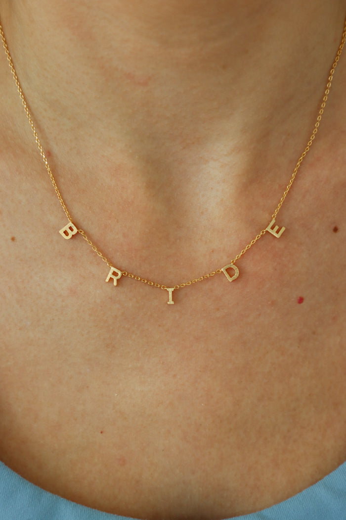 girl wearing gold "bride" necklace