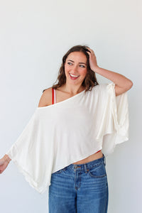Woman wearing a white top and blue jeans against a white background