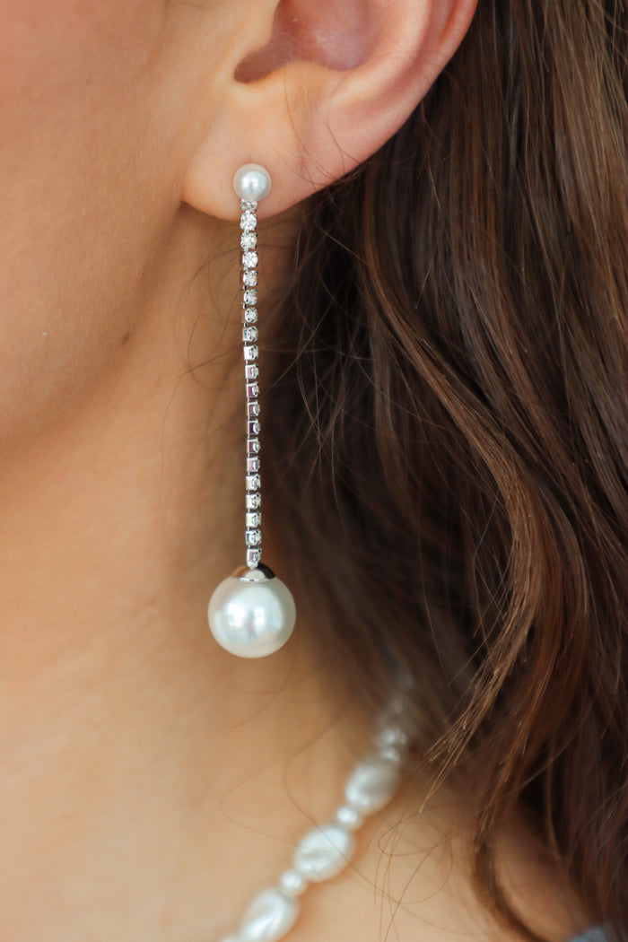 girl wearing silver rhinestone earring with pearl detailing