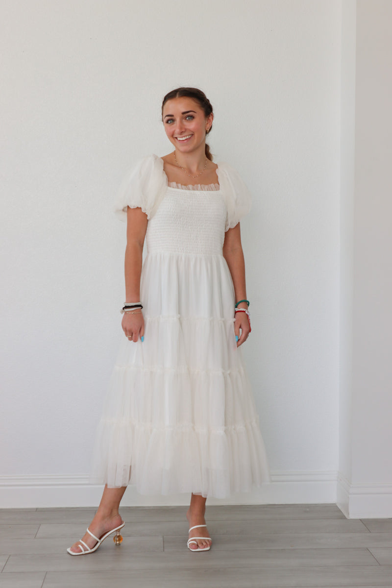 girl wearing long white dress with tulle detailing