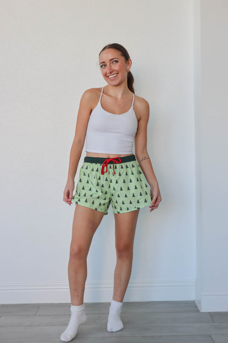 girl wearing green christmas tree pajama shorts