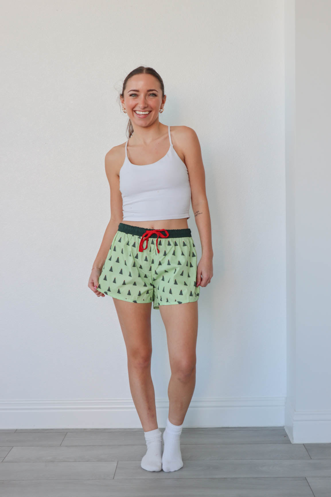 girl wearing green christmas tree pajama shorts