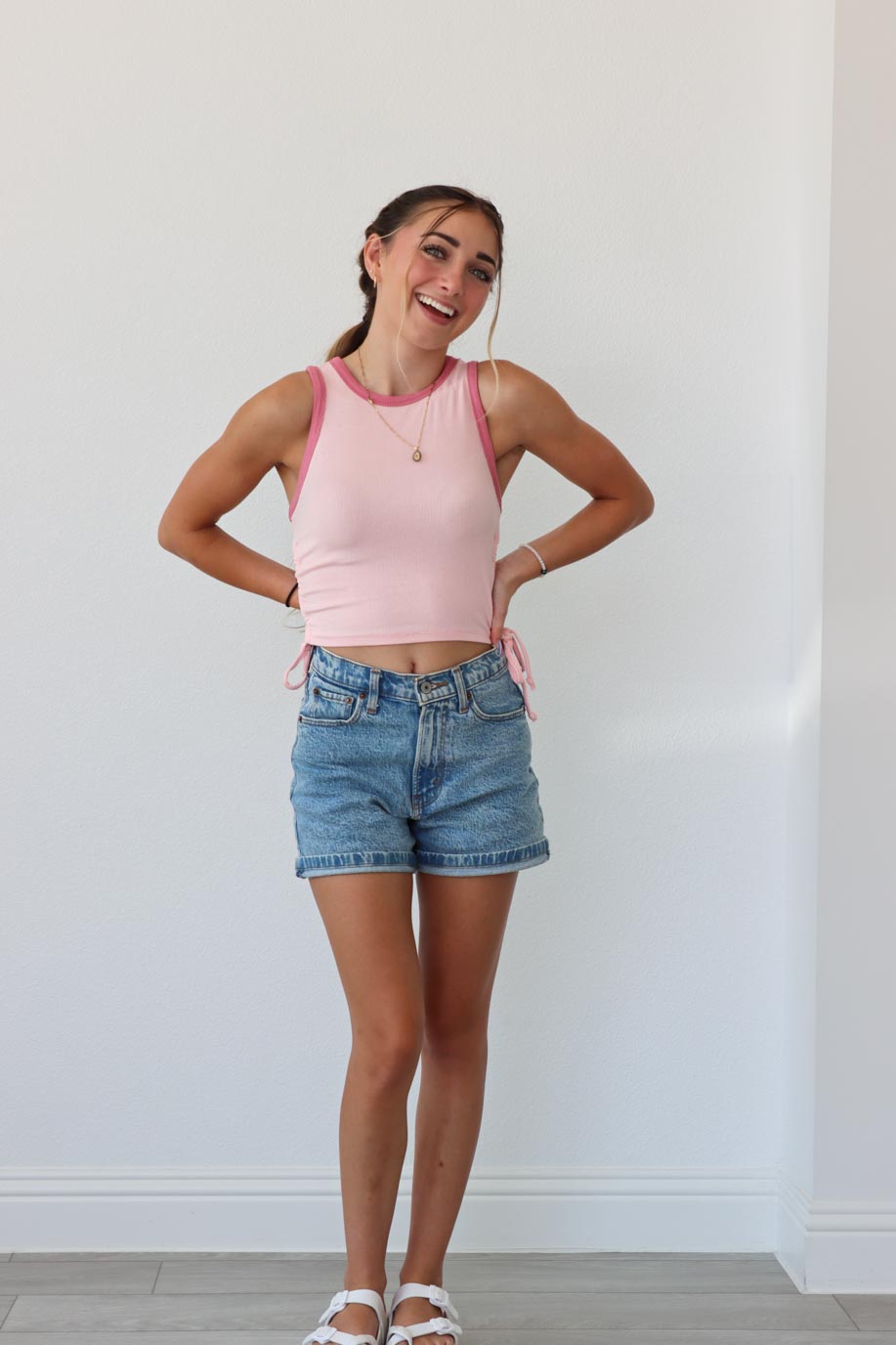 girl wearing light pink tank top with ruched side detailing