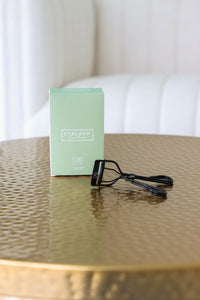 green LND curler box with black eyelash curler