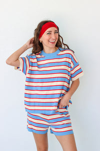 Woman wearing a blue and red striped outfit with a headband against a white background