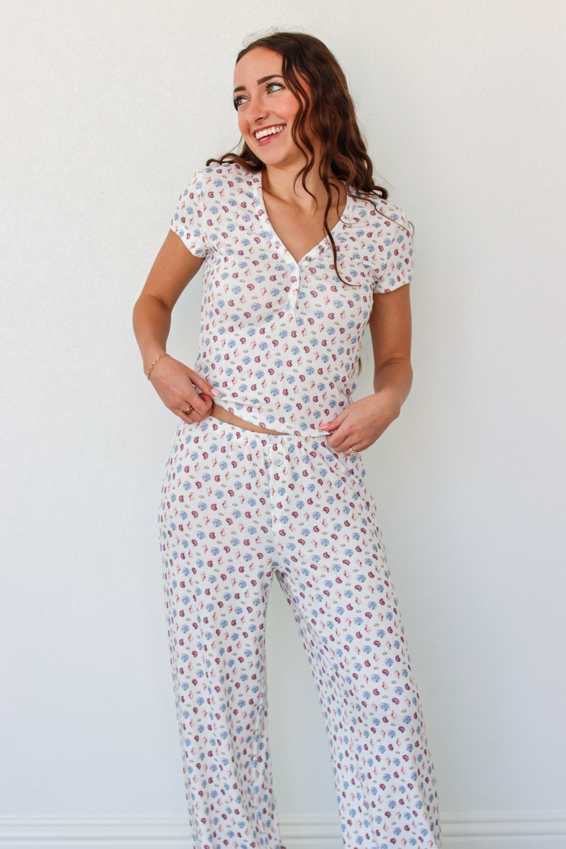 Woman wearing a short sleeve top and pant PJ set with seashell prints 