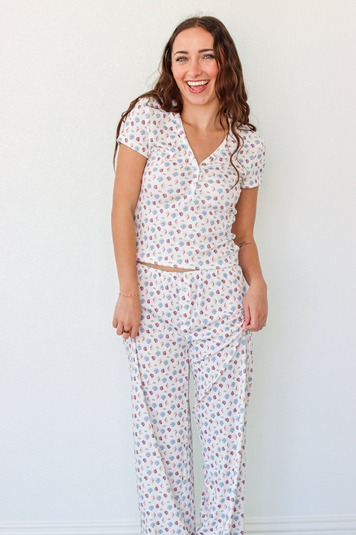 Woman wearing a seashell pajama set against a white background