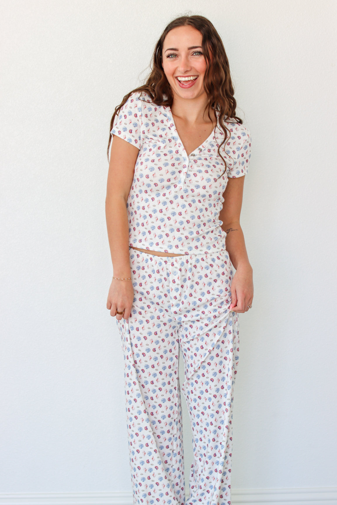 Woman wearing a short sleeve top and pant PJ set with seashell prints 