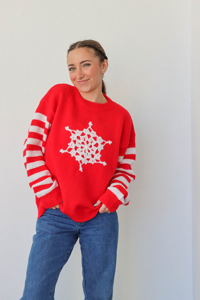 girl wearing red snowflake and striped sweater