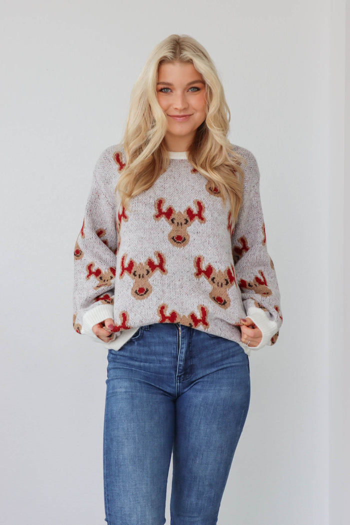 girl wearing knit reindeer sweater