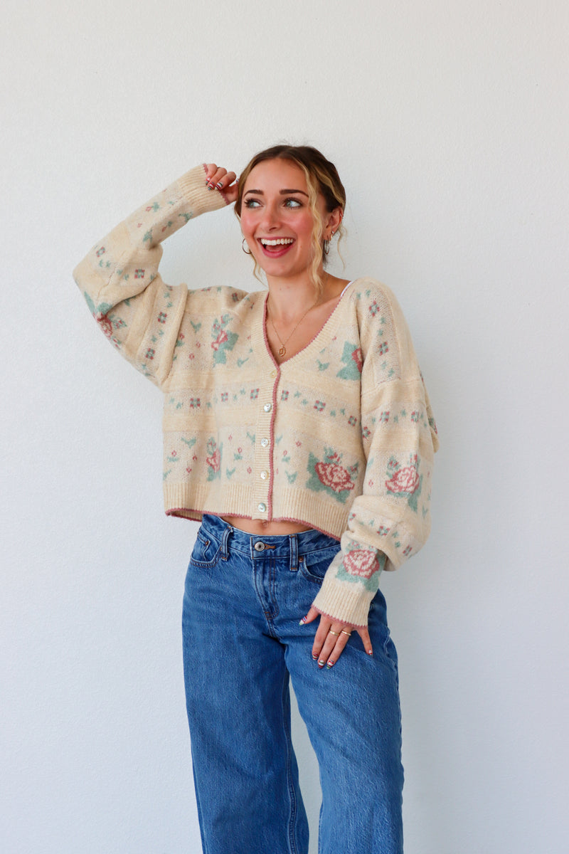 Woman wearing a floral blouse and blue jeans against a white background