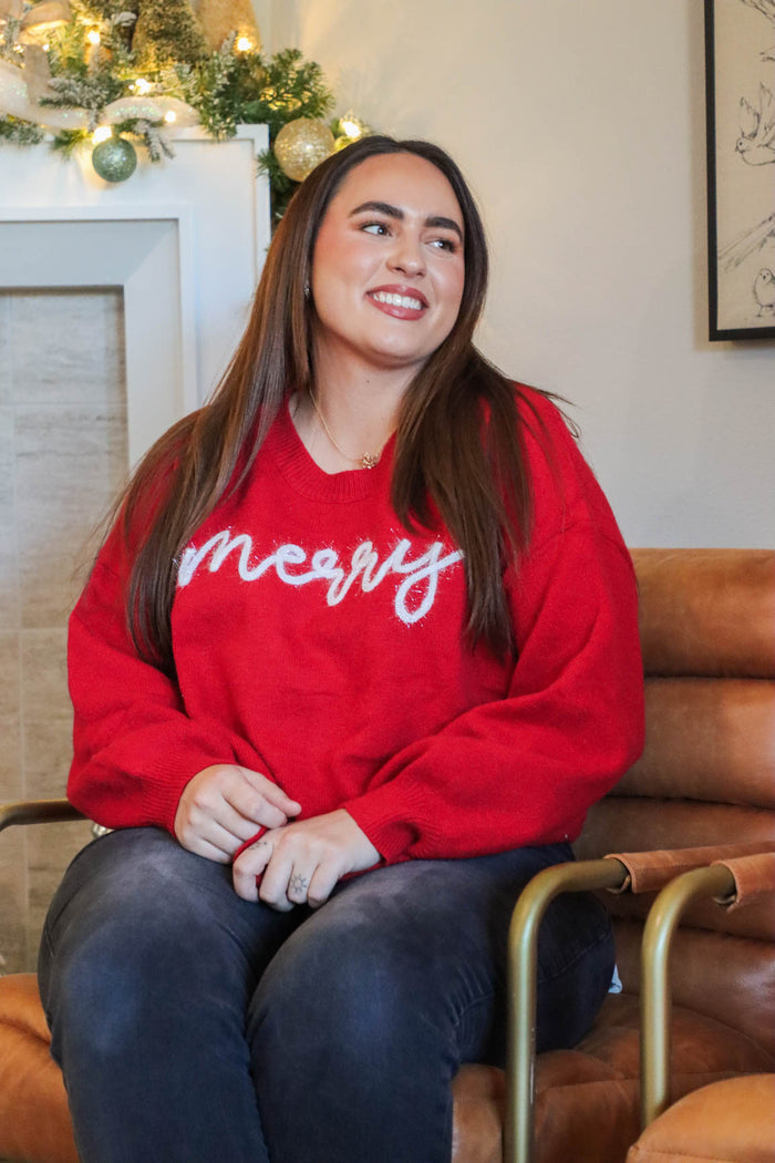 girl wearing red "merry" sweater with white tinsel lettering