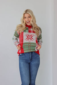 girl wearing christmas red and green knit sweater