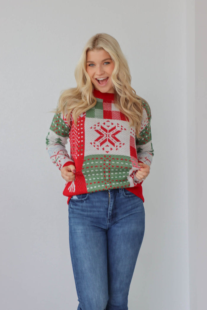 girl wearing christmas red and green knit sweater