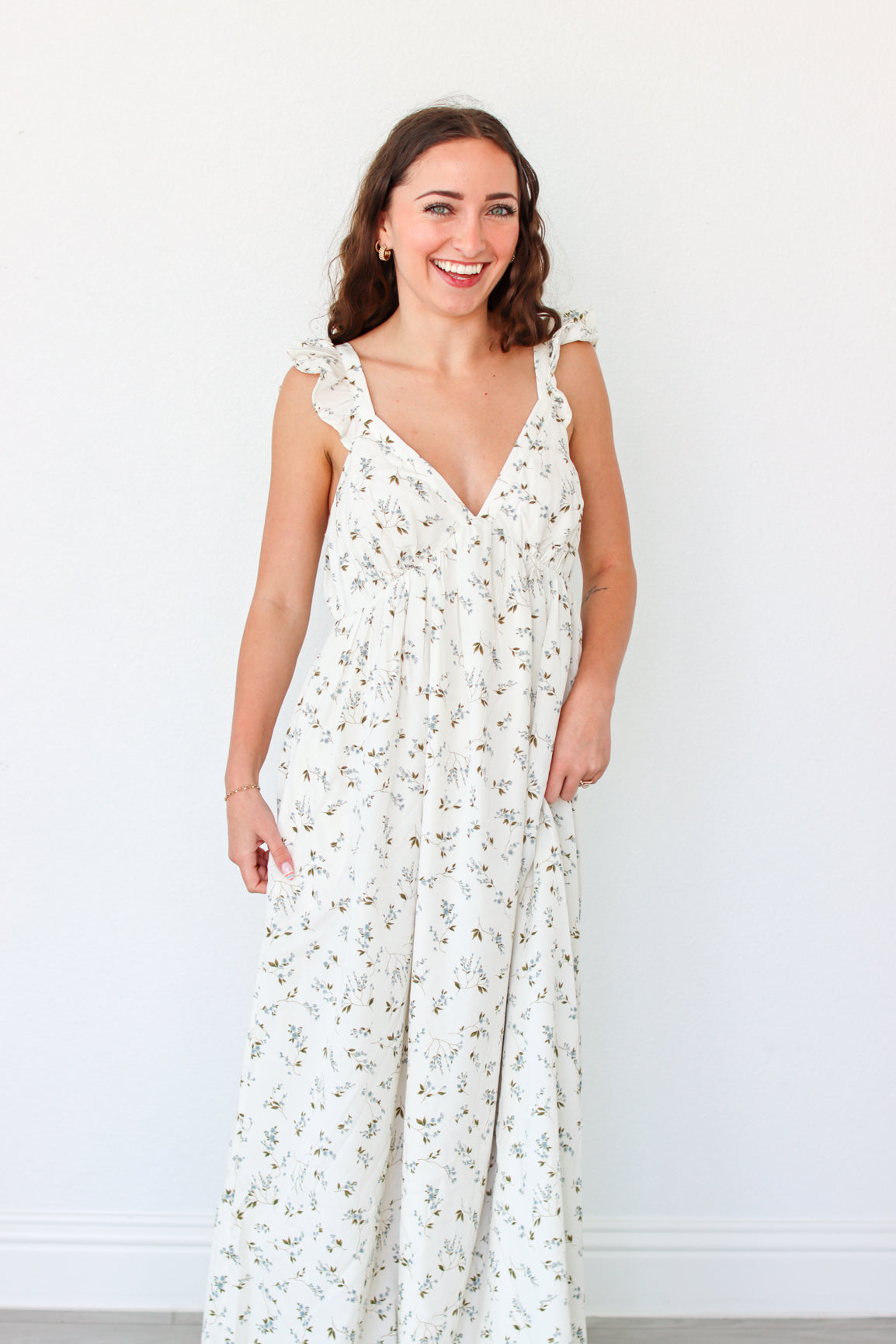 Woman wearing a white floral dress against a white background