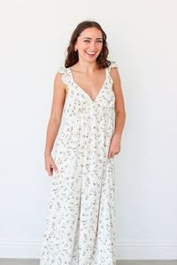 Woman wearing a white floral dress against a white background