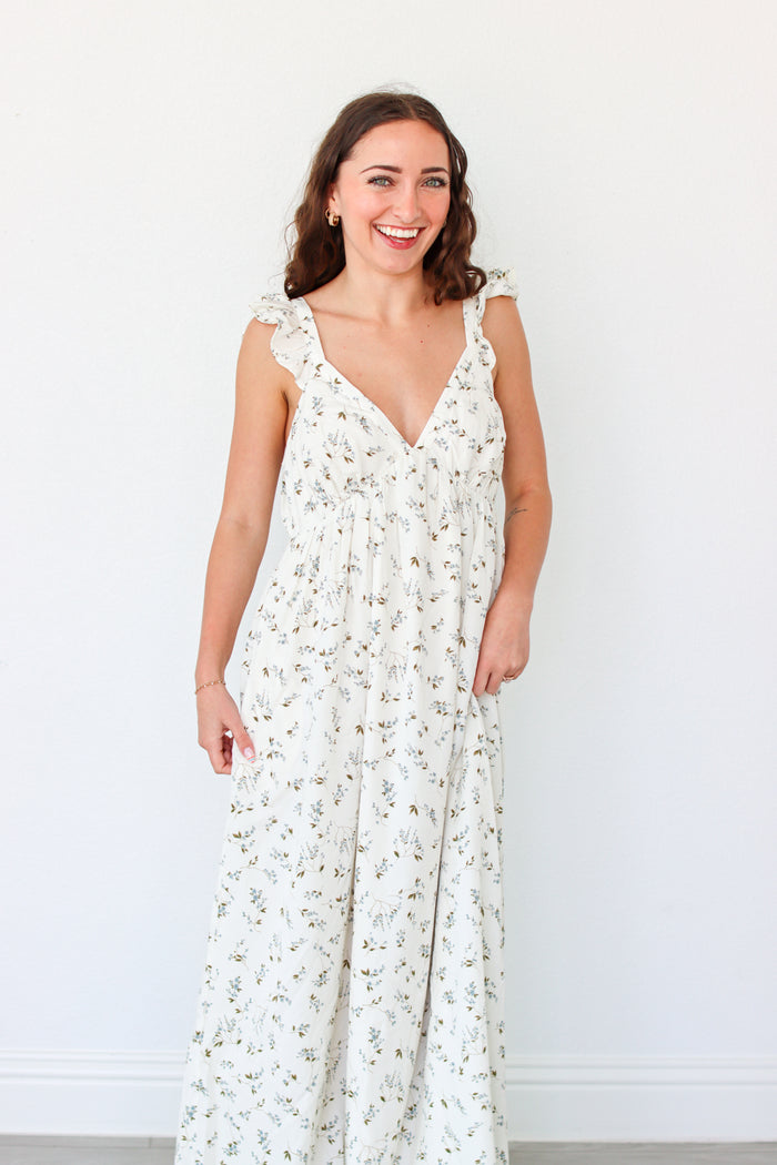 Woman wearing a white floral dress against a white background