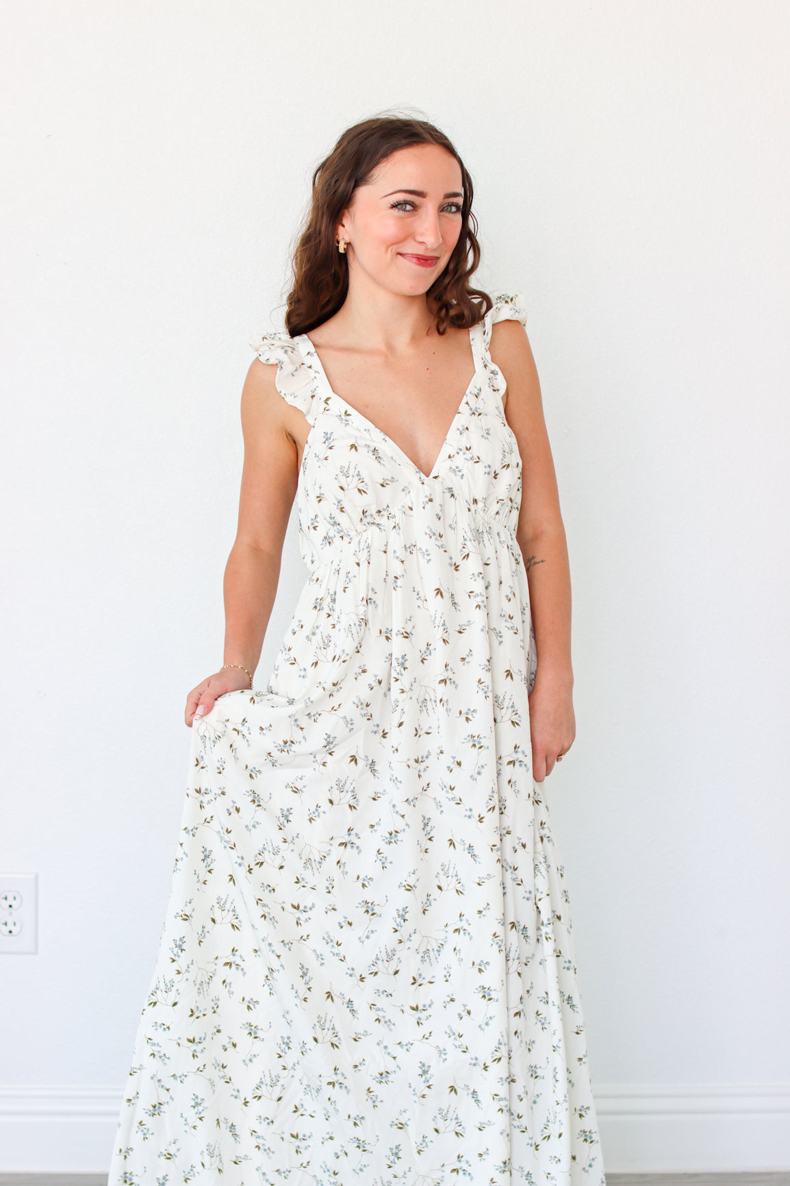 Woman wearing a white floral dress against a white background