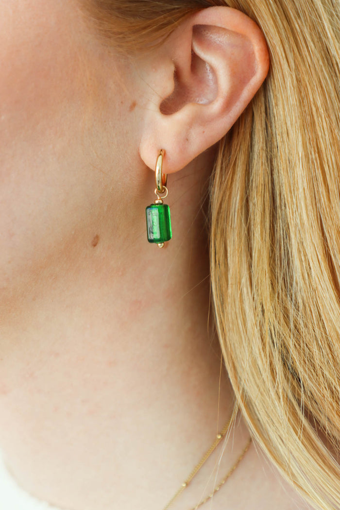 girl wearing green drop earrings