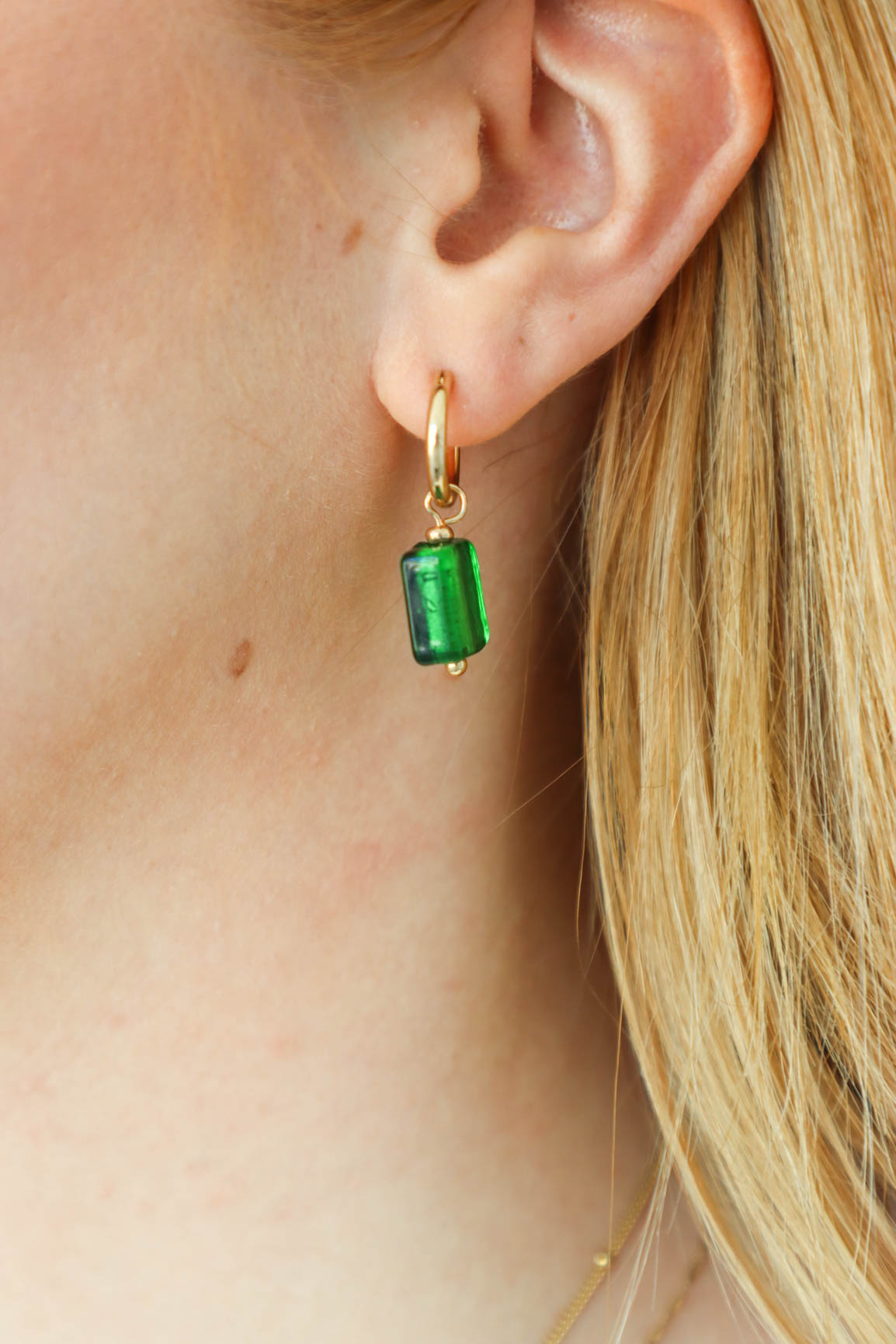 girl wearing green drop earrings