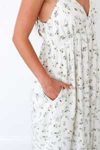 White floral dress with a plain background and pockets