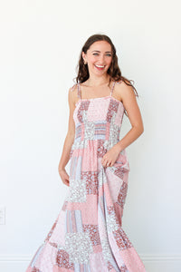 Woman wearing a pink floral patchwork dress against a white background