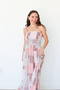 Woman wearing a pink floral patchwork dress against a white background