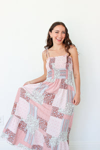 Woman wearing a pink floral patchwork dress against a white background