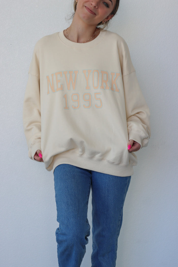 girl wearing cream "new york 1995" crewneck