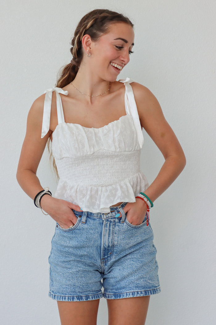 girl wearing white tank top with bow straps